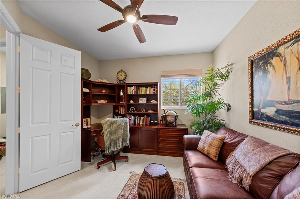 Office with light carpet and ceiling fan