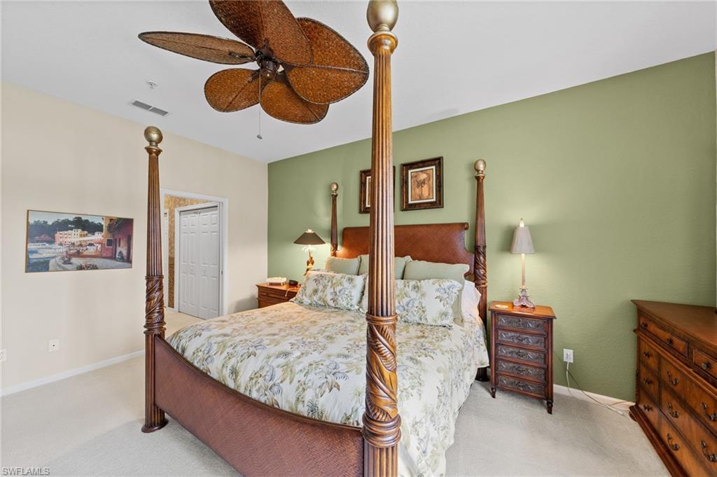 Bedroom with ceiling fan and light carpet