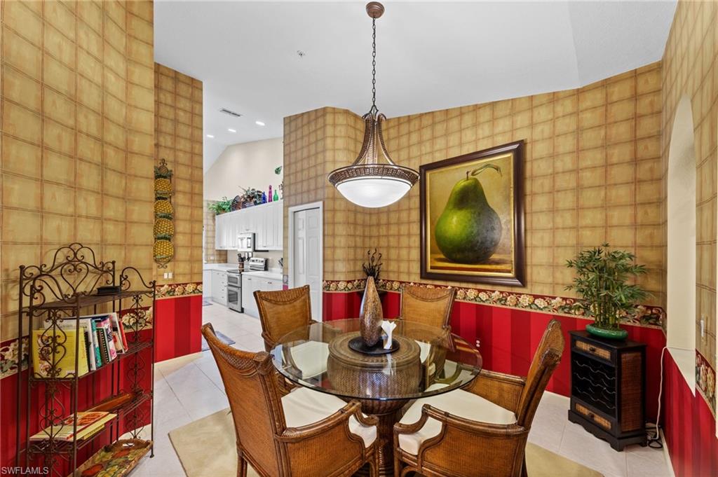 Dining area with recessed lighting, wallpapered walls, light tile patterned flooring, and lofted ceiling