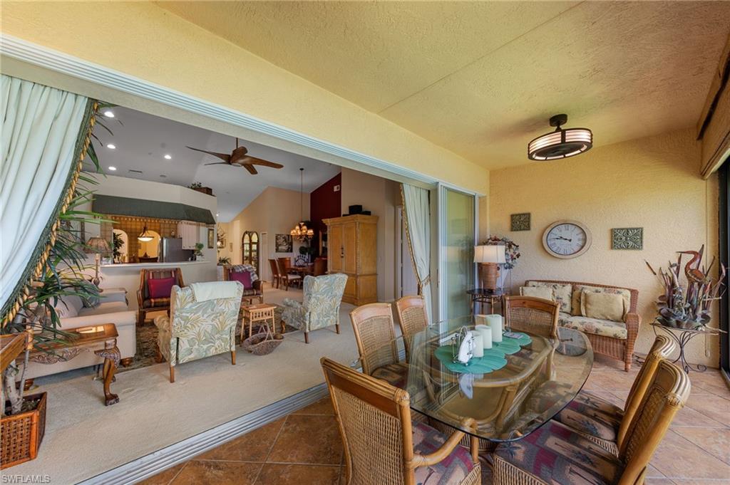 Tiled dining area featuring ceiling fan, a textured wall, and a textured ceiling