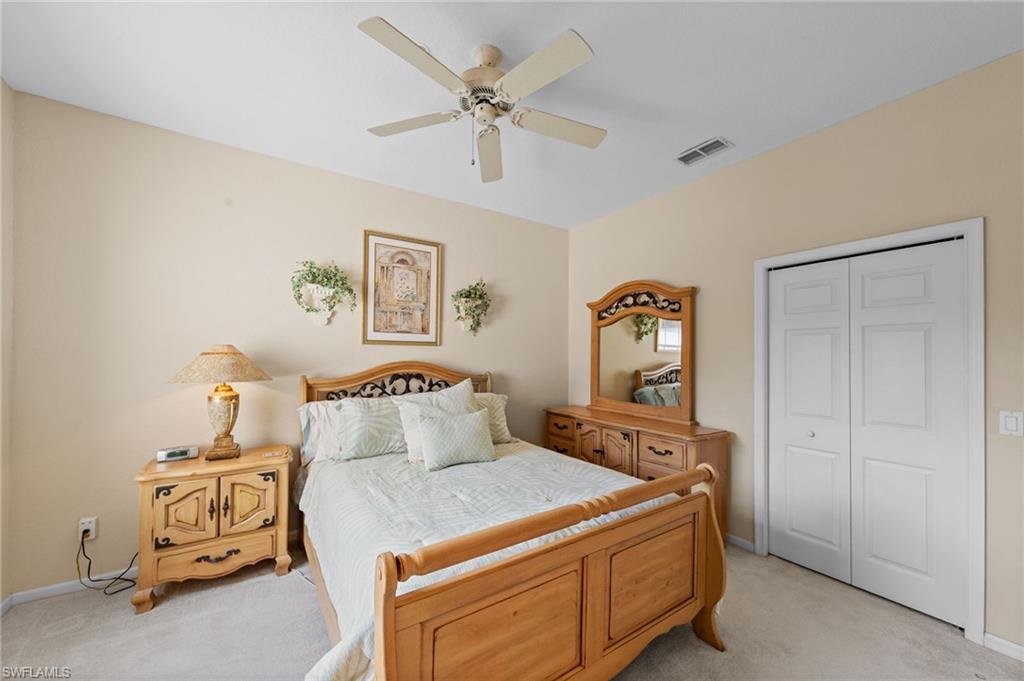 Bedroom featuring a closet, light colored carpet, and ceiling fan