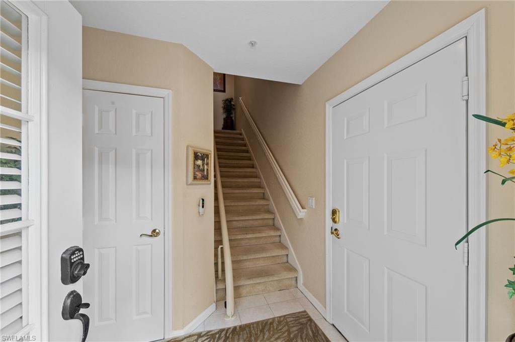 Stairs with tile patterned floors and baseboards