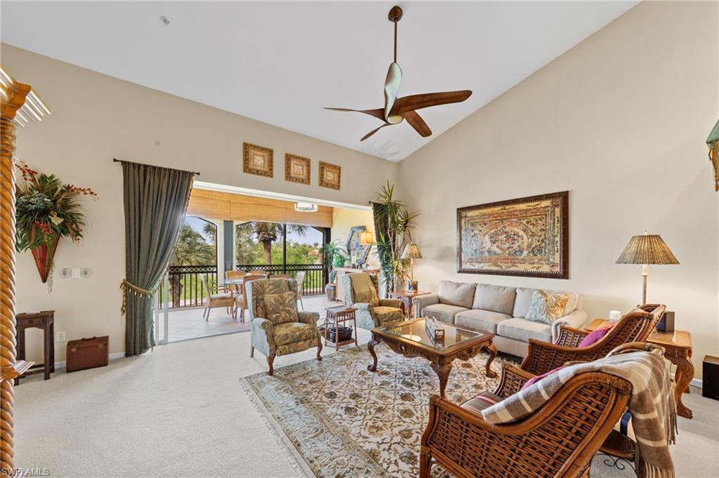 Living room with light carpet, ceiling fan, and lofted ceiling
