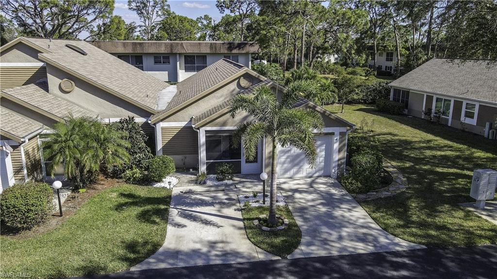 Property exterior featuring a single-car garage, concrete driveway, and mature landscaping
