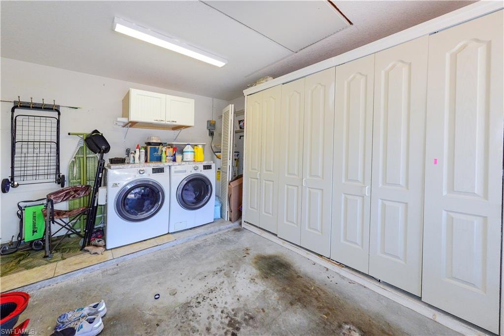 Dedicated laundry area featuring a built-in countertop, upper cabinetry, and a full wall of integrated storage units