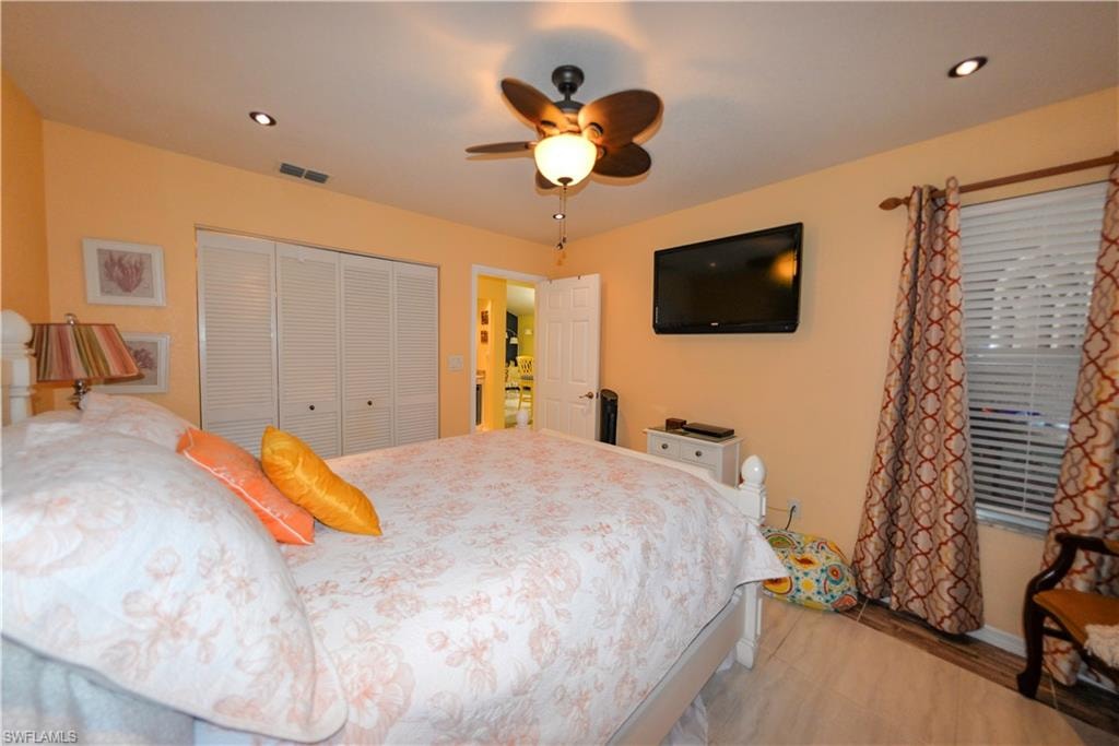 Recessed lighting, wood-finish flooring, and louvered bifold closet doors