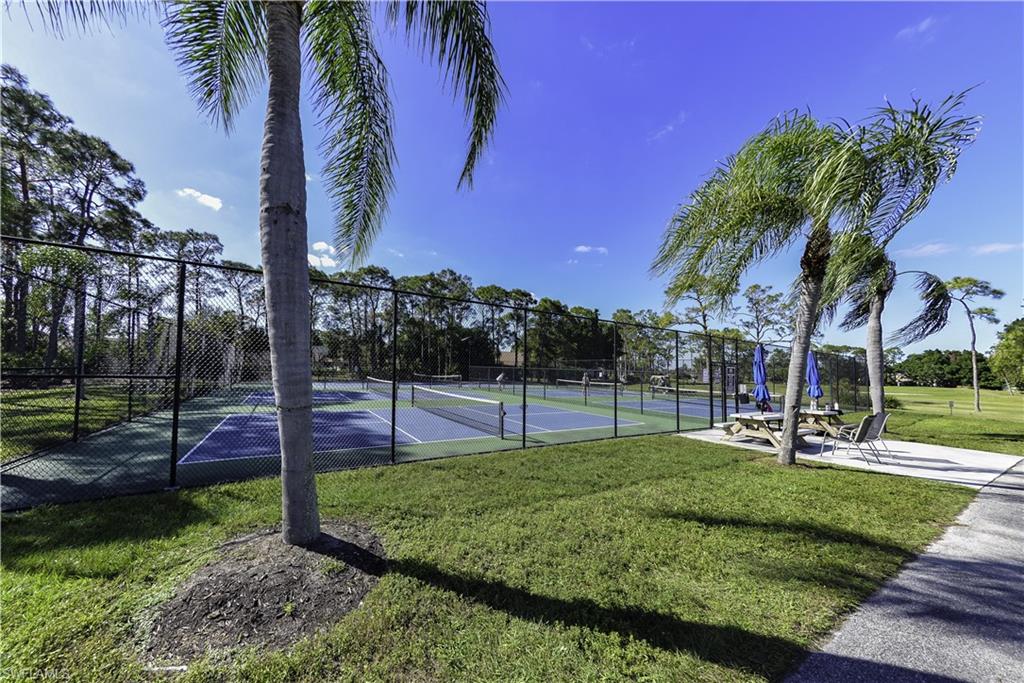 Fenced tennis courts with blue and green surfaces
