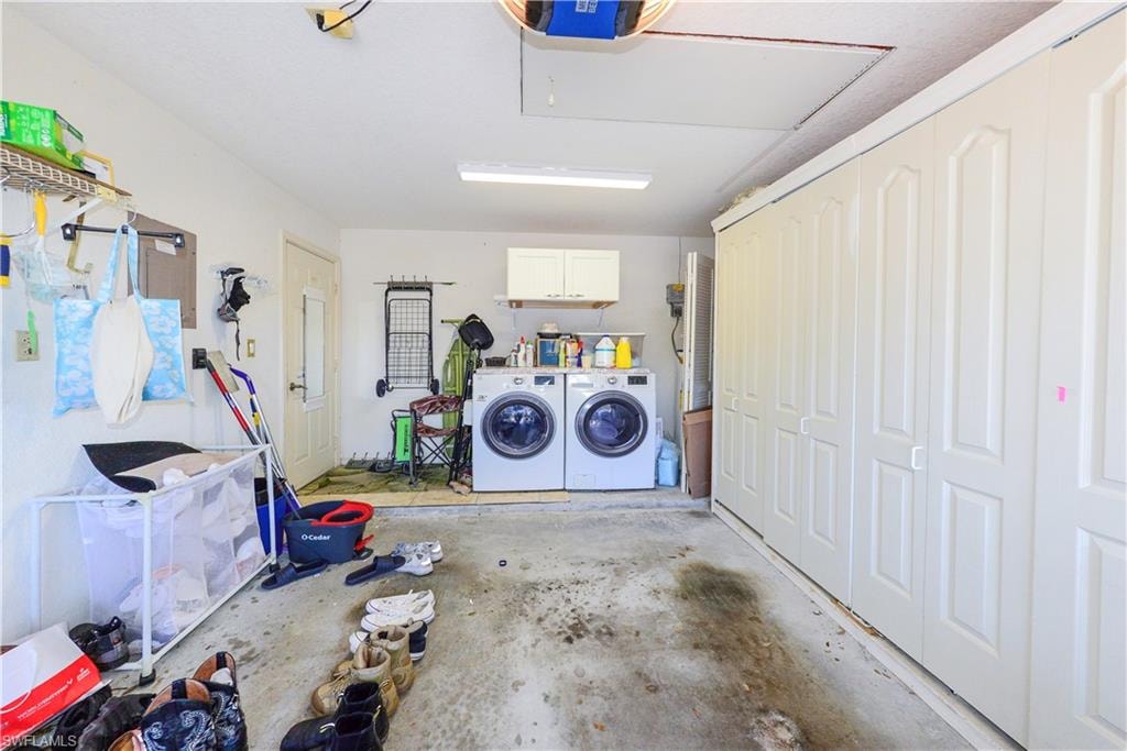 Garage space featuring a washer and dryer, upper cabinetry, a utility door, and extensive built-in storage solutions