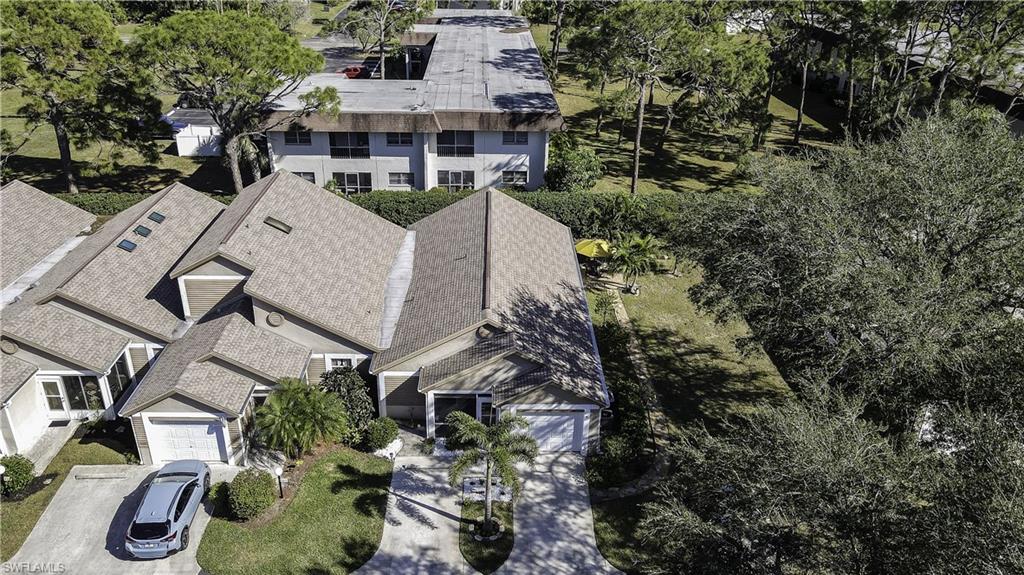 Residential property featuring a shingle roof and a paved driveway