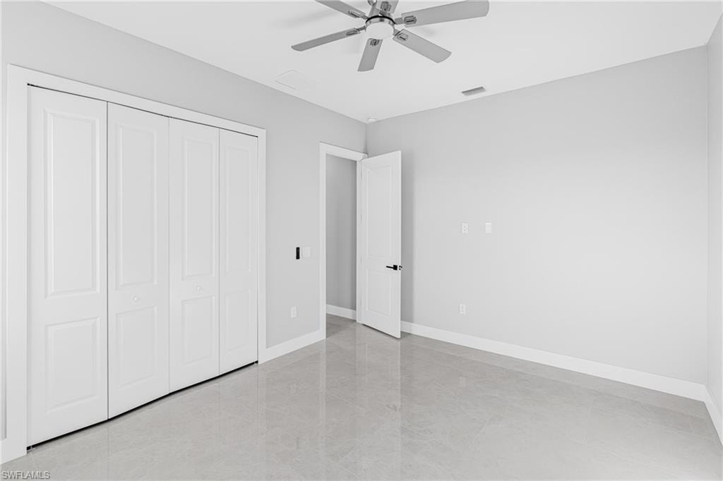 Unfurnished bedroom featuring a ceiling fan and a closet