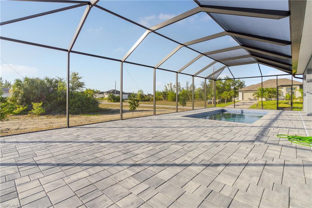 Swimming pool featuring a sunroom, a lanai, and a patio