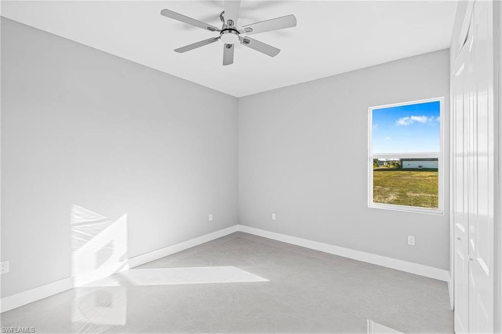 Unfurnished room featuring a ceiling fan and concrete flooring