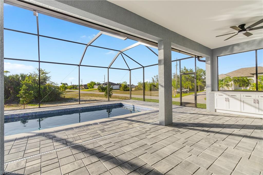 View of patio / terrace with a lanai, an outdoor pool, ceiling fan, and a sunroom