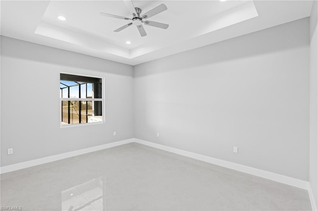 Unfurnished room with a tray ceiling, recessed lighting, and ceiling fan