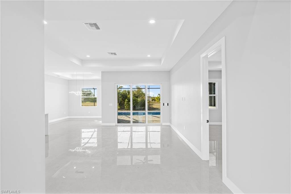 Unfurnished room featuring a raised ceiling and recessed lighting