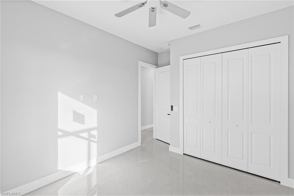 Unfurnished bedroom featuring a ceiling fan and a closet