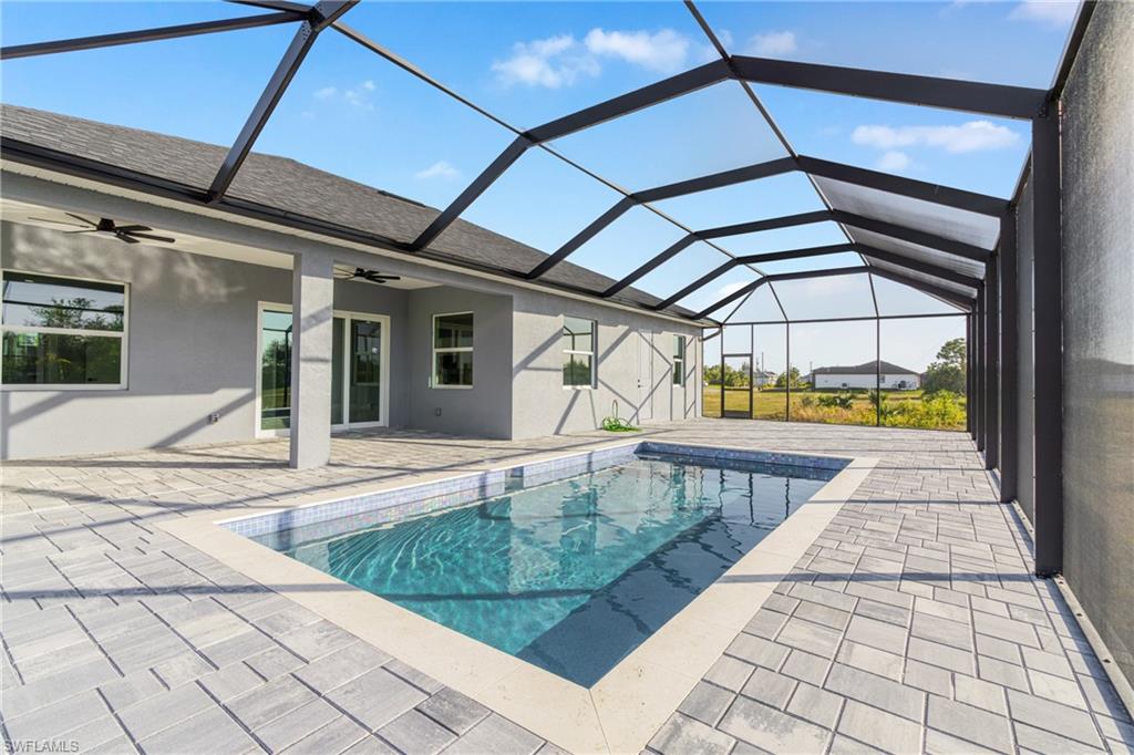 Swimming pool with a sunroom, a lanai, and a patio