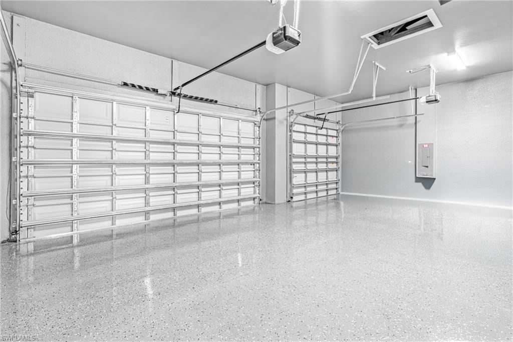 Garage featuring a garage door opener and electric panel