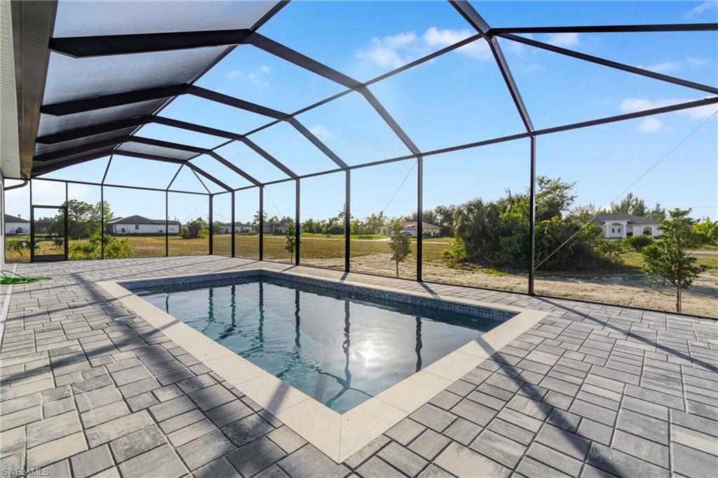 Outdoor pool featuring a sunroom, a lanai, and a patio