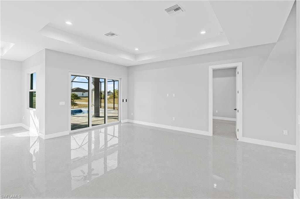 Unfurnished room featuring a raised ceiling and recessed lighting