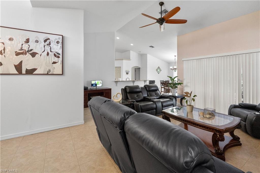 Living area with a ceiling fan, light tile patterned flooring, vaulted ceiling, and recessed lighting