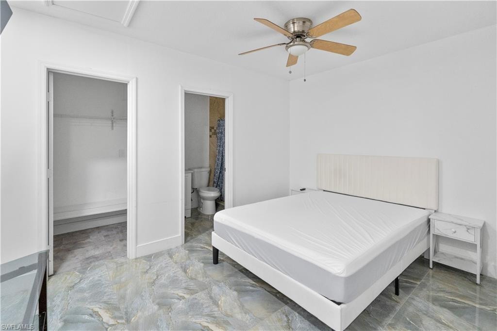 Bedroom featuring a spacious closet and ceiling fan