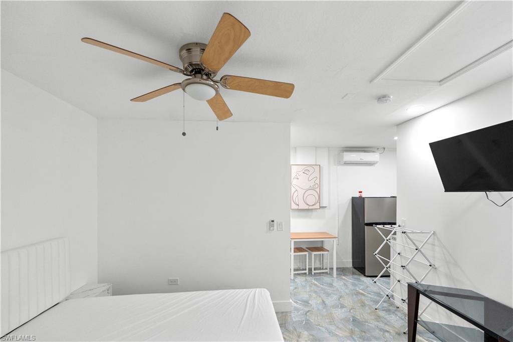 Bedroom with freestanding refrigerator, ceiling fan, and radiator heating unit