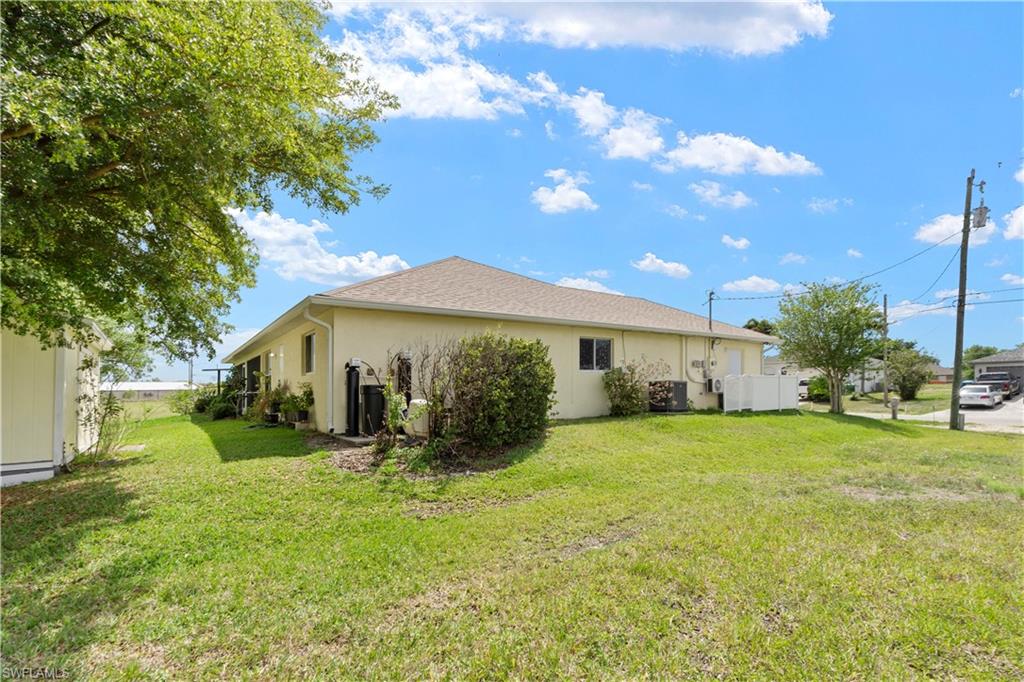 View of property exterior featuring stucco siding and a lawn
