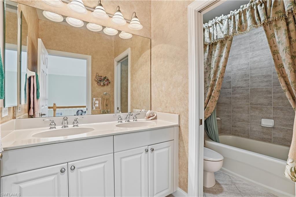 Guest bathroom with dual sinks and shower/tub combo.