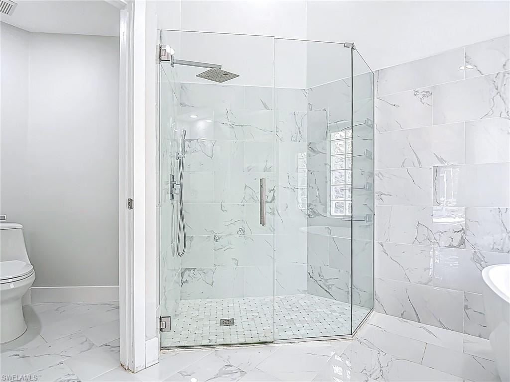 Full bath with toilet, baseboards, a marble finish shower, and marble finish floor