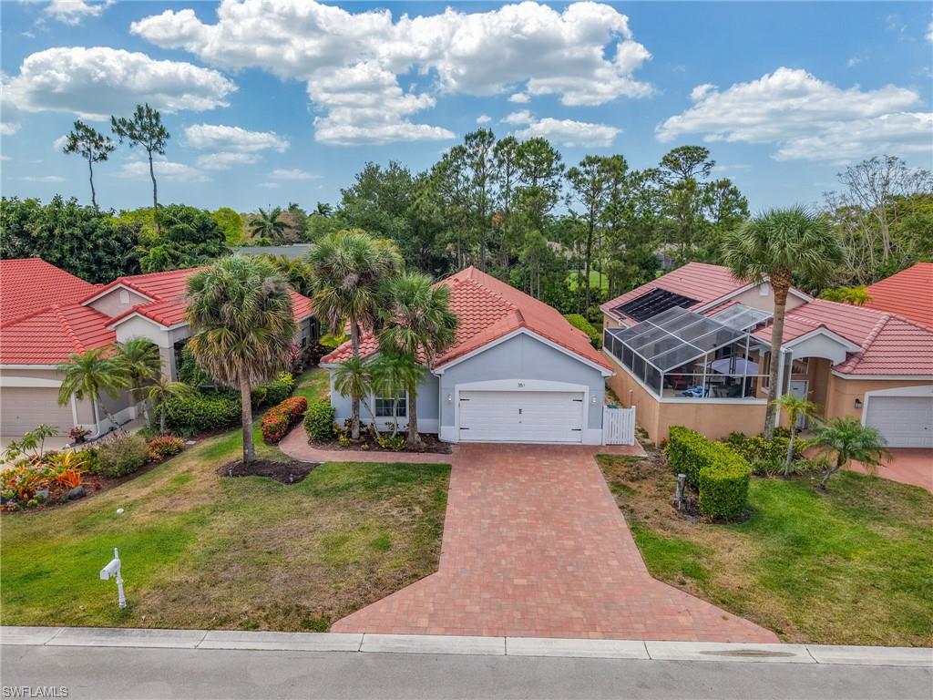 Mediterranean / spanish-style home with a garage, a tile roof, decorative driveway, and a front yard