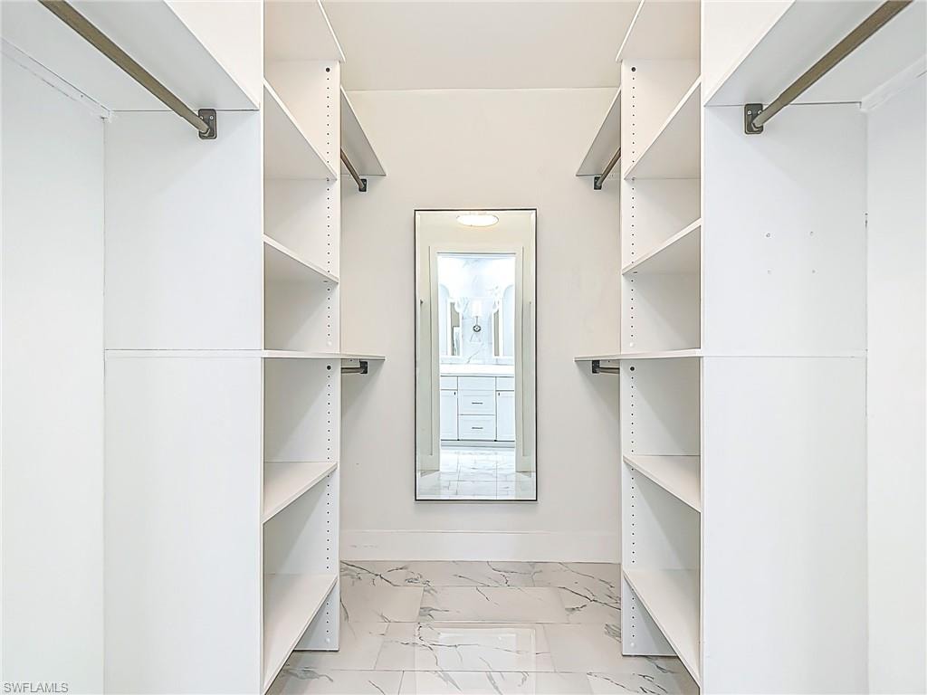 Walk in closet with marble finish floor