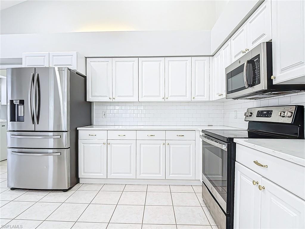 Kitchen featuring light countertops, light tile patterned floors, white cabinets, and stainless steel appliances