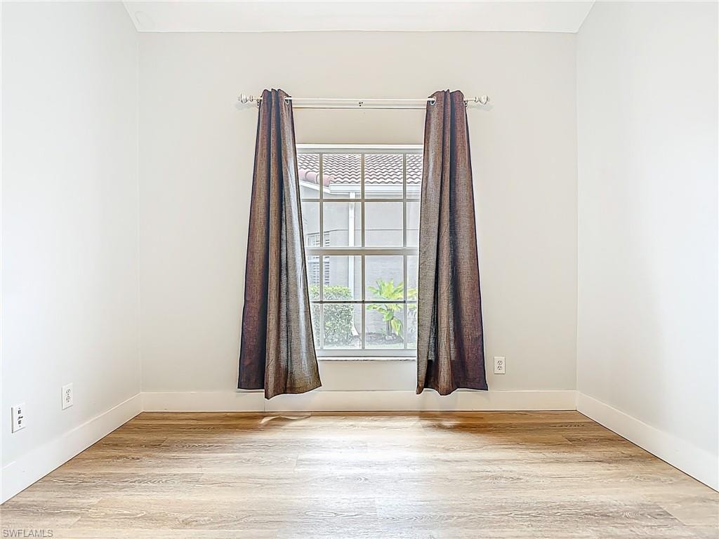 Unfurnished room with light wood-style floors and baseboards