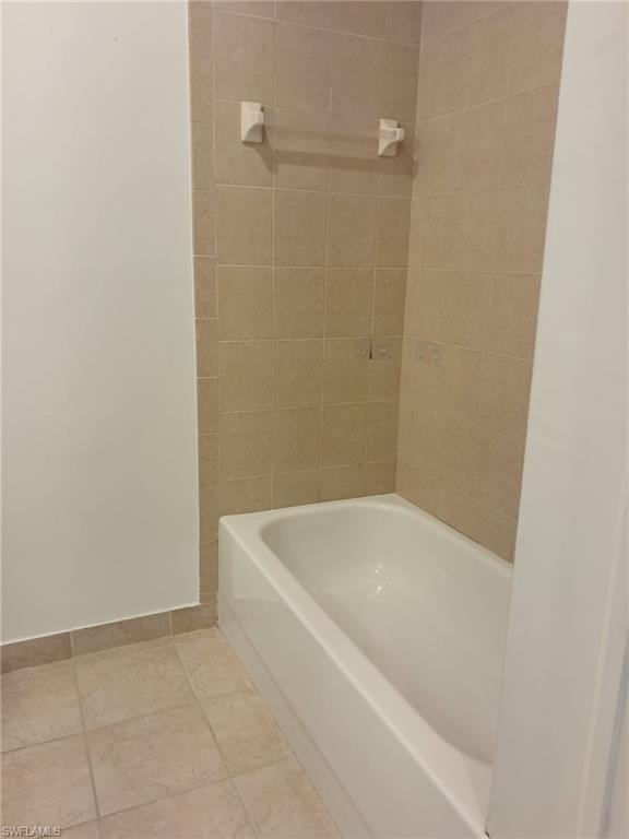 Bathroom vanity featuring a white ceramic sink, chrome faucet, and integrated light-colored countertop