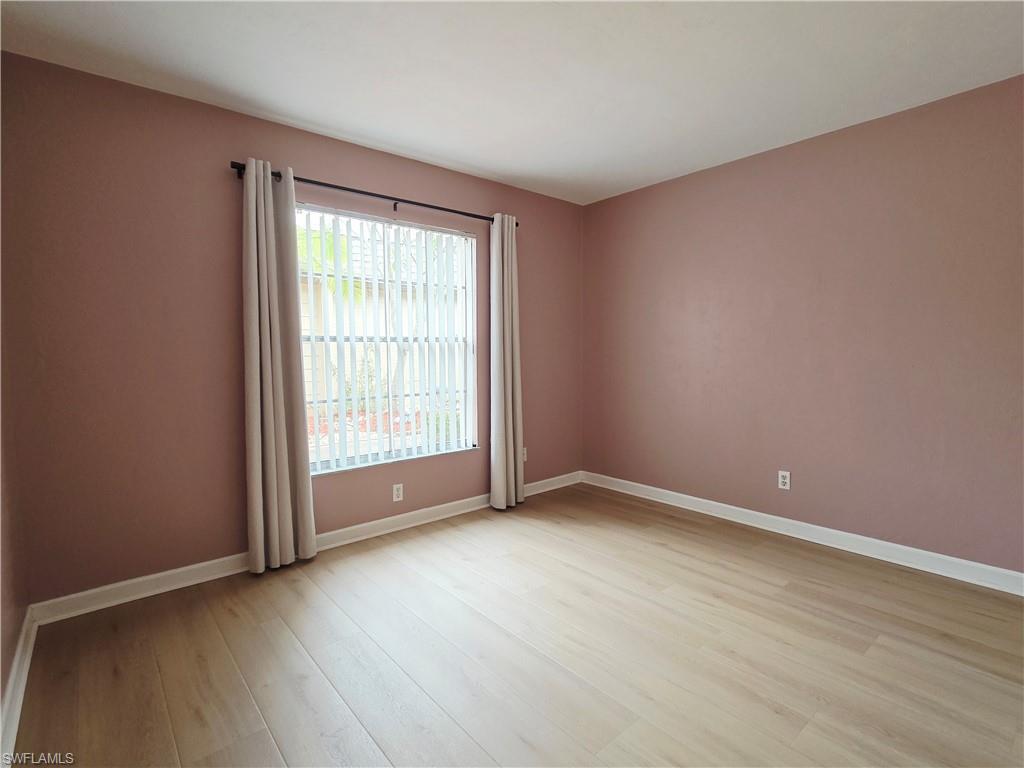 Spare room with baseboards and light wood finished floors