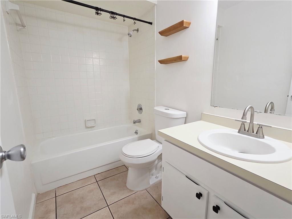 Bathroom featuring vanity,  shower combination, and light tile patterned floors