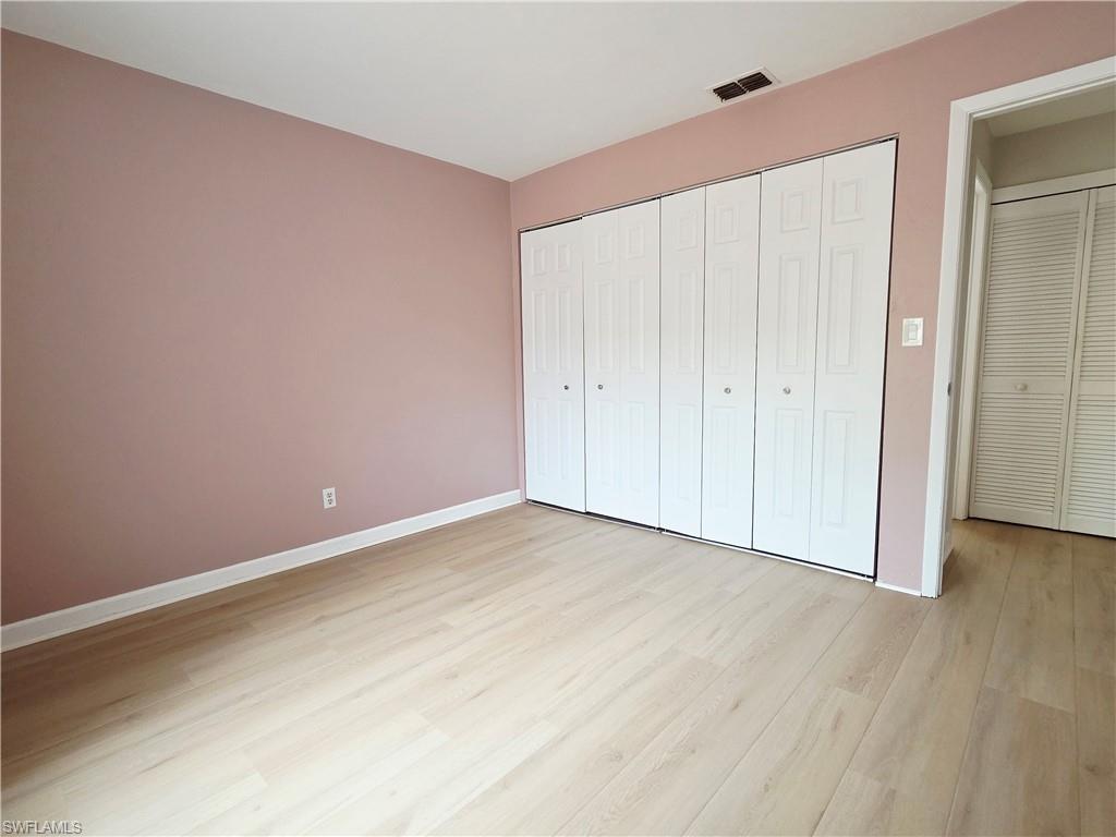 Unfurnished bedroom with light wood-style flooring and a closet