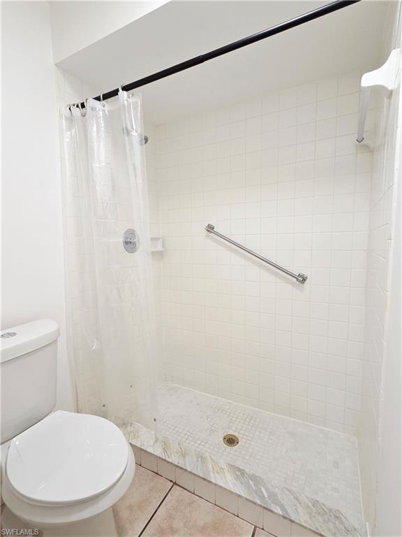 Bathroom with a shower stall and light tile patterned floors