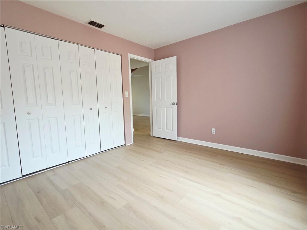 Unfurnished bedroom featuring light wood finished floors and a closet