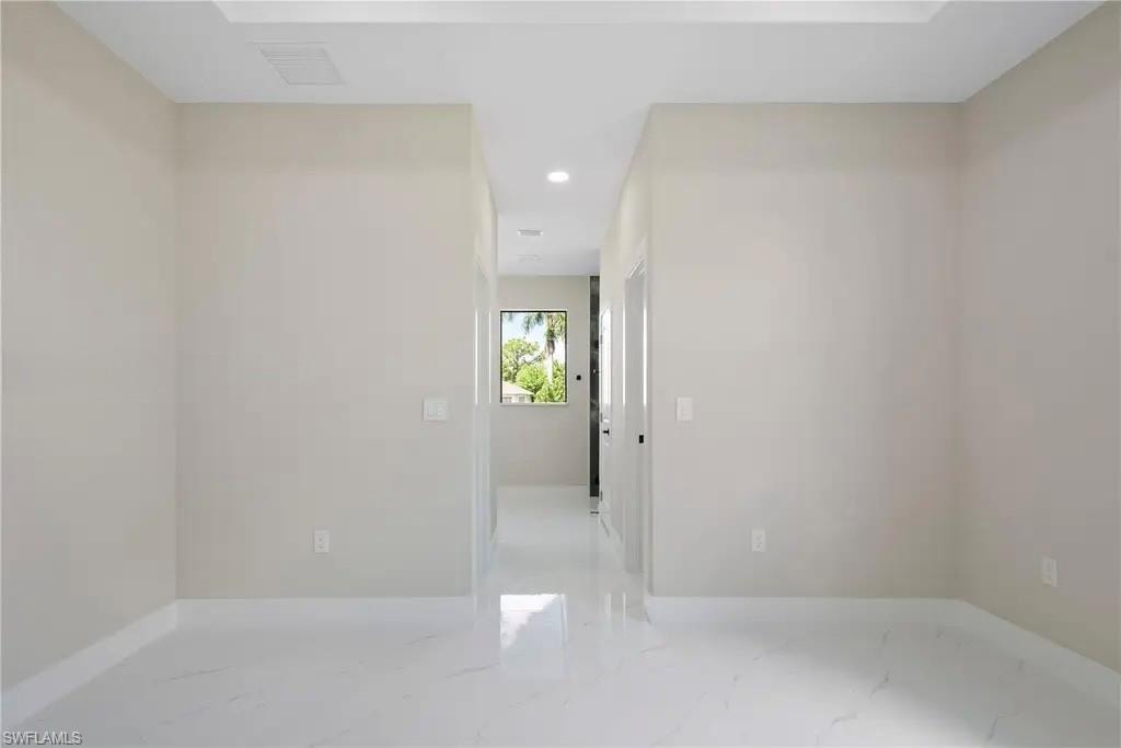 Unfurnished room featuring recessed lighting and light marble finish flooring