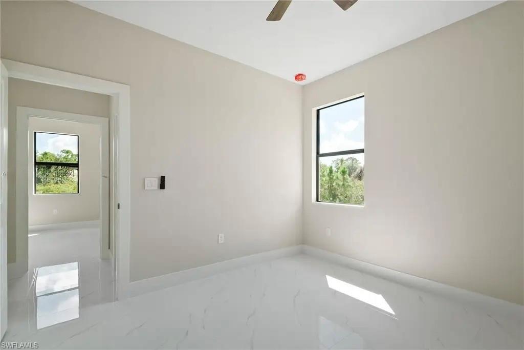 Spare room featuring ceiling fan and light marble finish floors