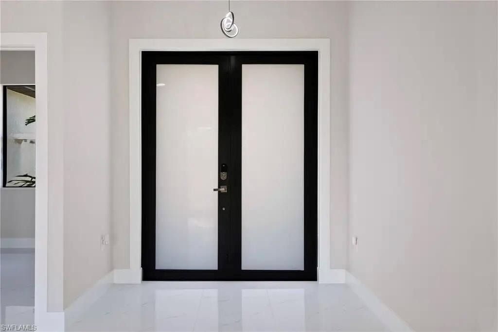 Entryway with french doors and light marble finish flooring