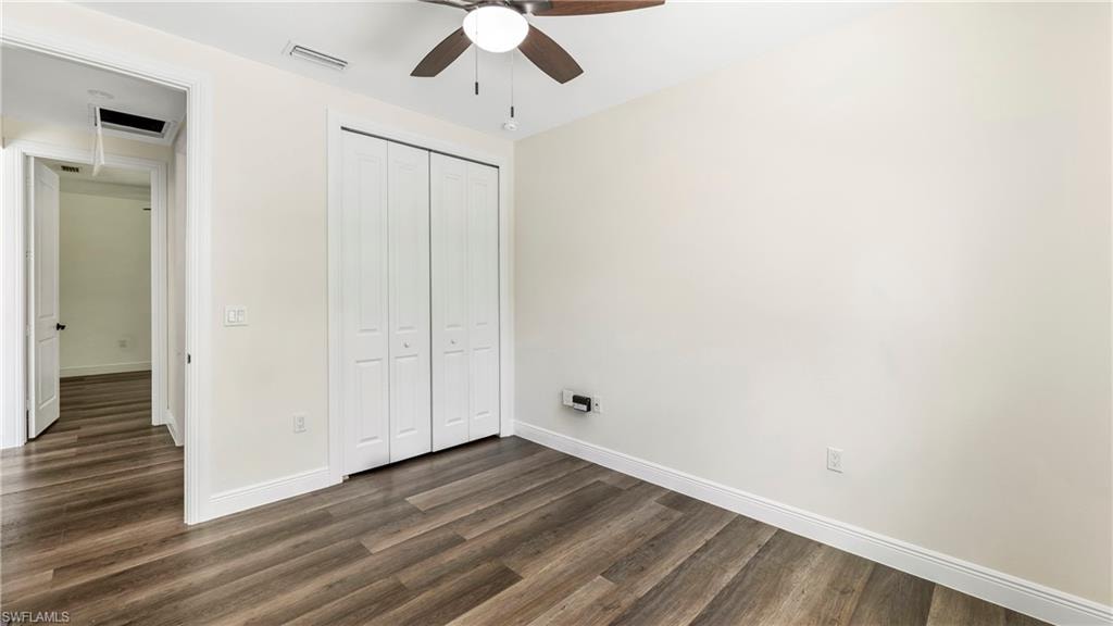 Unfurnished bedroom with dark wood-style floors, a closet, and ceiling fan