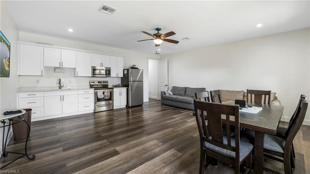 Dining room featuring ceiling fan, dark wood-style flooring, and recessed lighting