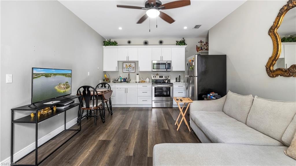 Living area with ceiling fan, dark wood finished floors, and recessed lighting