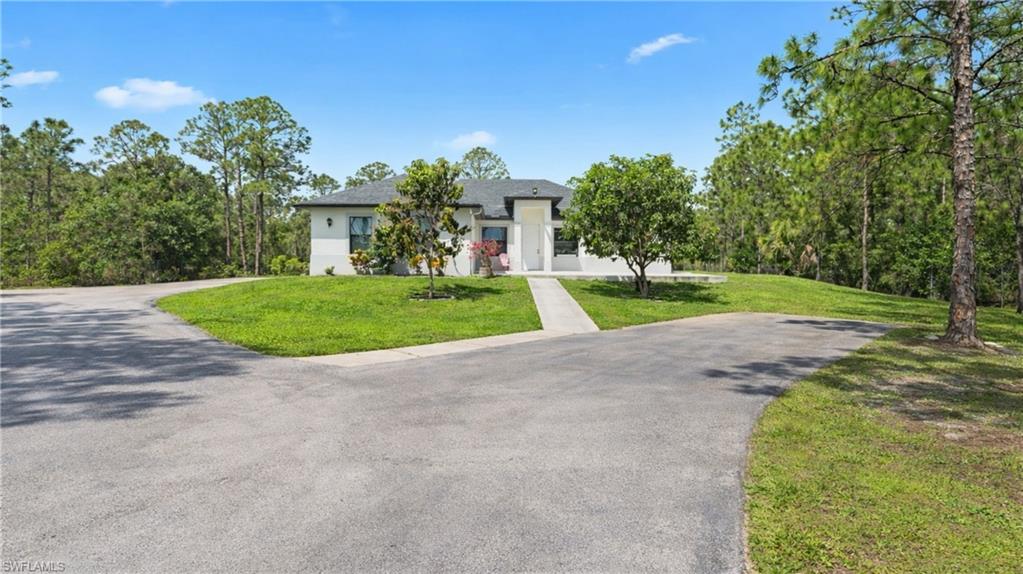 View of front of property featuring a front yard and asphalt driveway