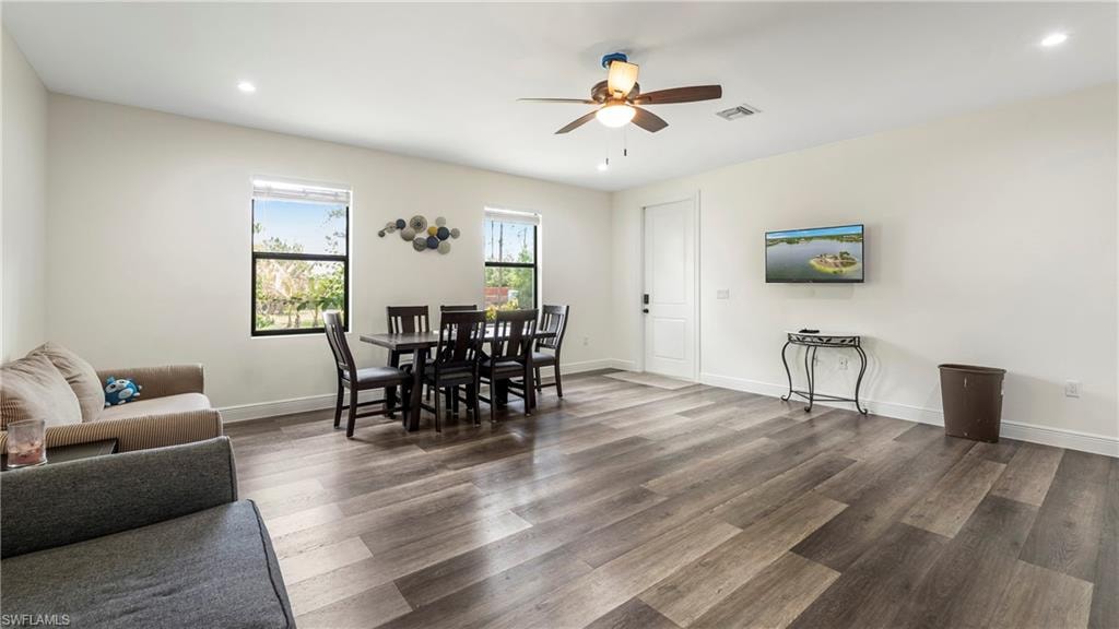 Dining room featuring dark wood-style flooring, ceiling fan, and recessed lighting