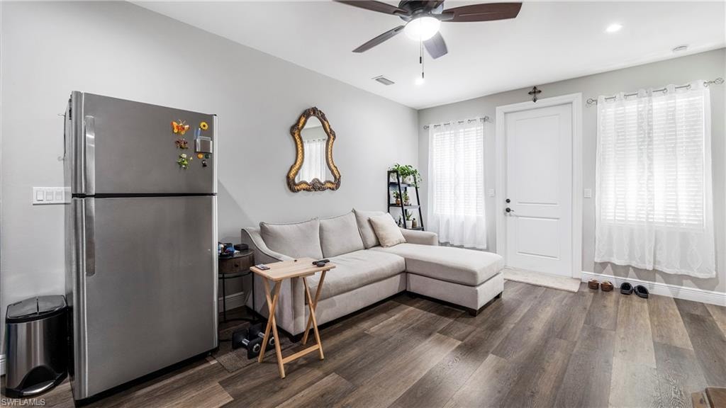 Living area with dark wood-style floors, a ceiling fan, and recessed lighting