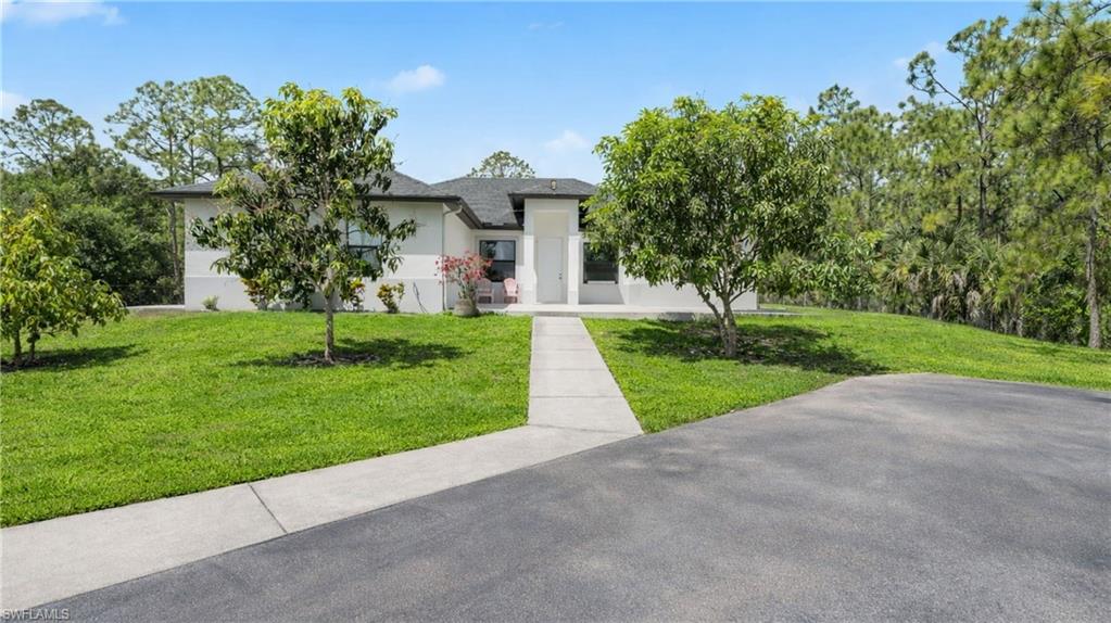 View of front of home with a front lawn and stucco siding